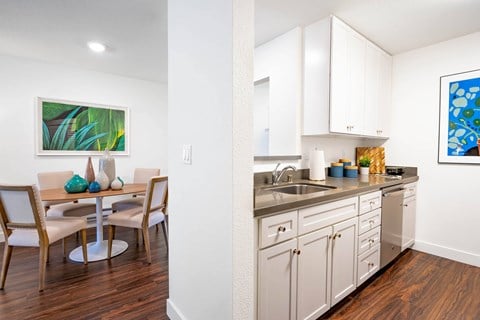 A kitchen with a dining table and chairs.