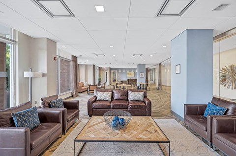 A spacious living room with brown leather couches and a wooden coffee table.