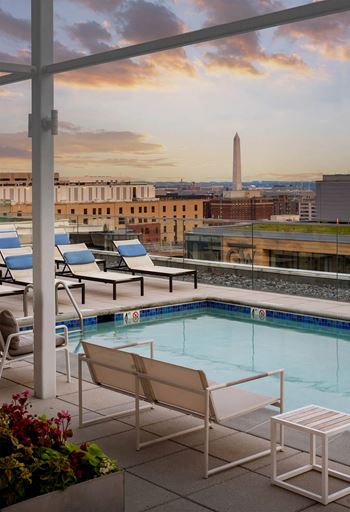 A pool area with chairs and a view of the Washington Monument.