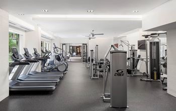 A gym with treadmills, weights, and exercise equipment.