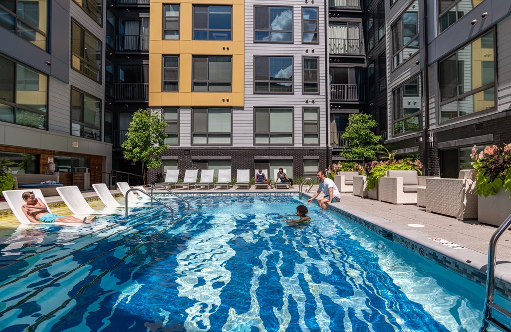 A swimming pool in a courtyard surrounded by buildings.