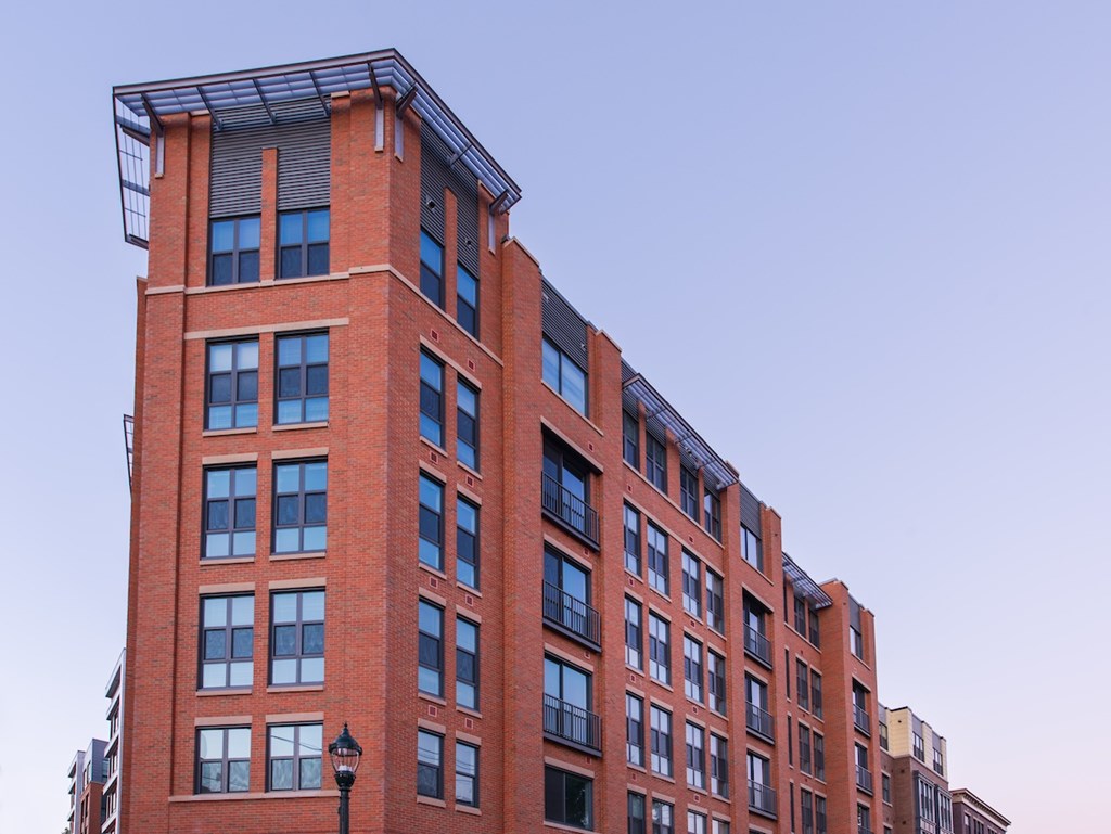 A tall red brick building with a black lamp post in front.