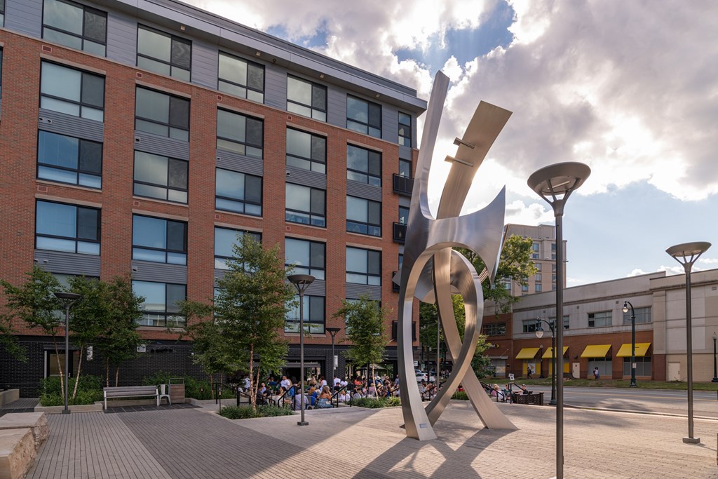 A large metal sculpture in front of a brick building.