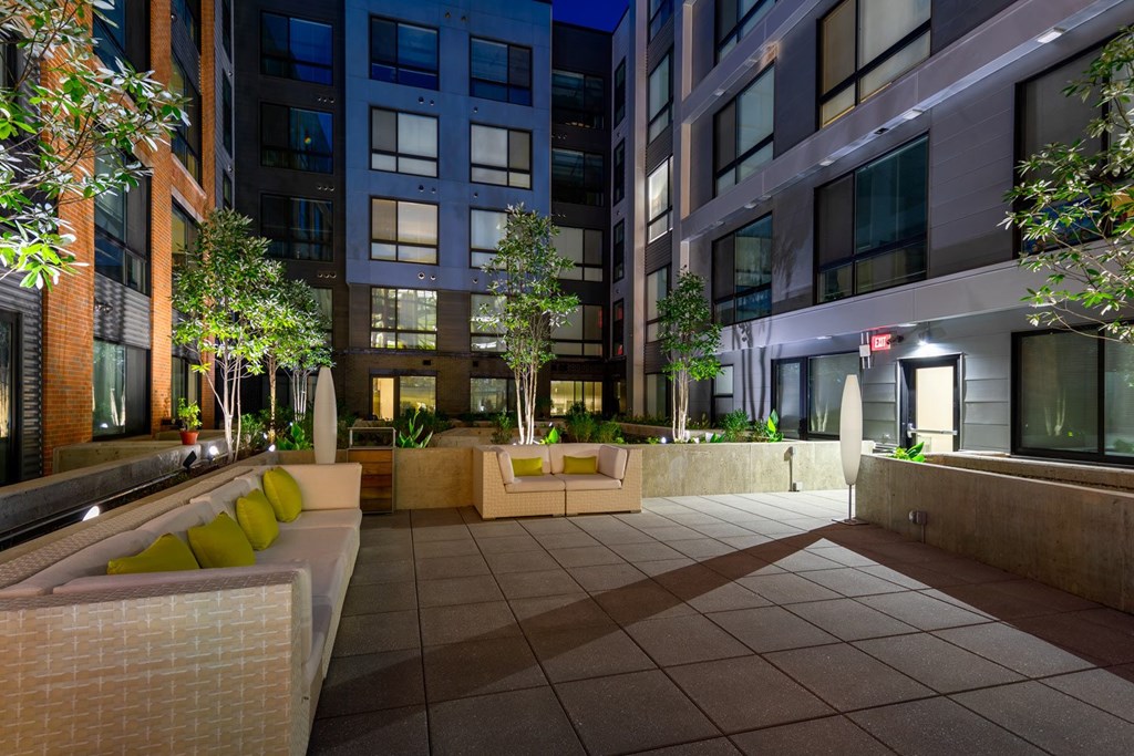 A courtyard with a bench and a tree.