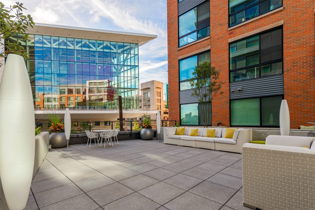 A modern outdoor seating area with white furniture and a large white sculpture.