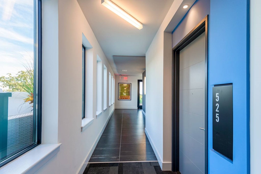 A long hallway with a blue door and a sign that says 525.