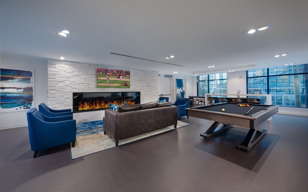 A room with a pool table and a fireplace.
