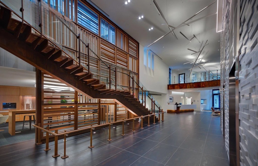 A wooden staircase with a metal railing leads to a second floor.