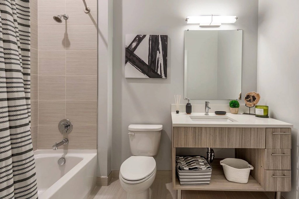 A bathroom with a toilet, sink, and a shower curtain.