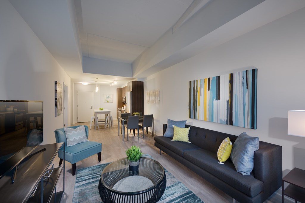 A living room with a black couch and a blue chair.