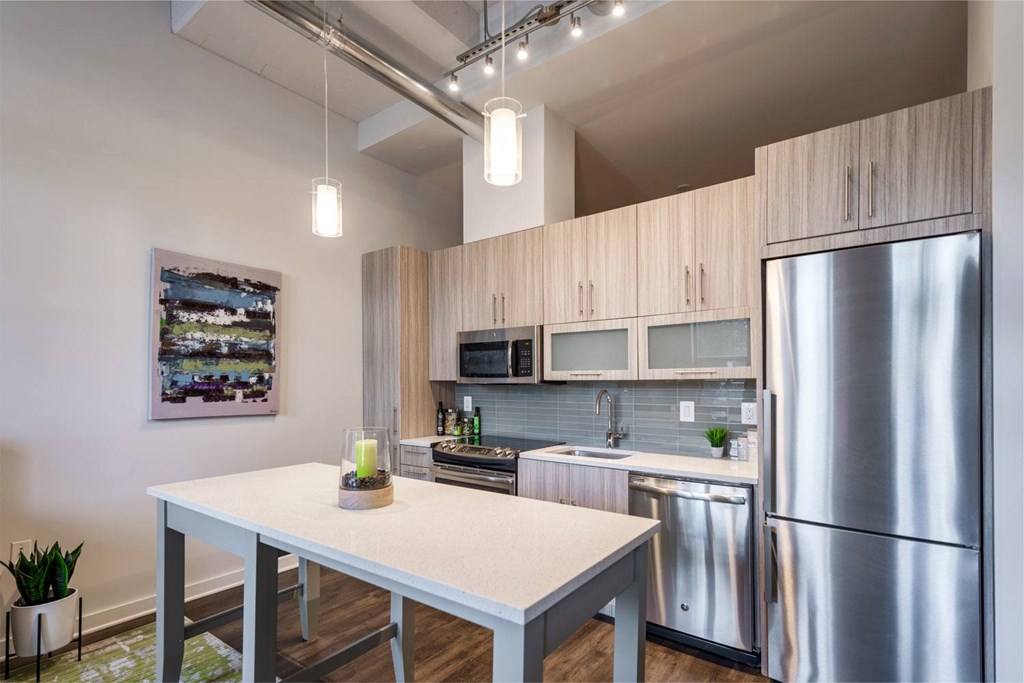 A modern kitchen with a stainless steel refrigerator and wooden cabinets.