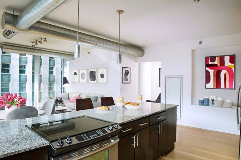A modern kitchen with a granite countertop and a stove top oven.