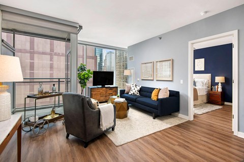 A living room with a blue couch and a grey chair.