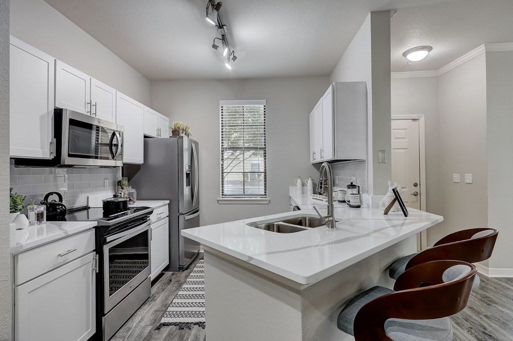 A modern kitchen with white appliances and a large island.