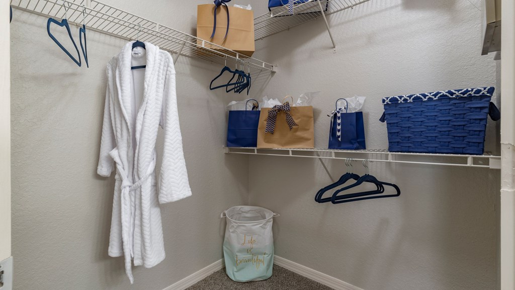 A white robe is hanging on a rack in a room.