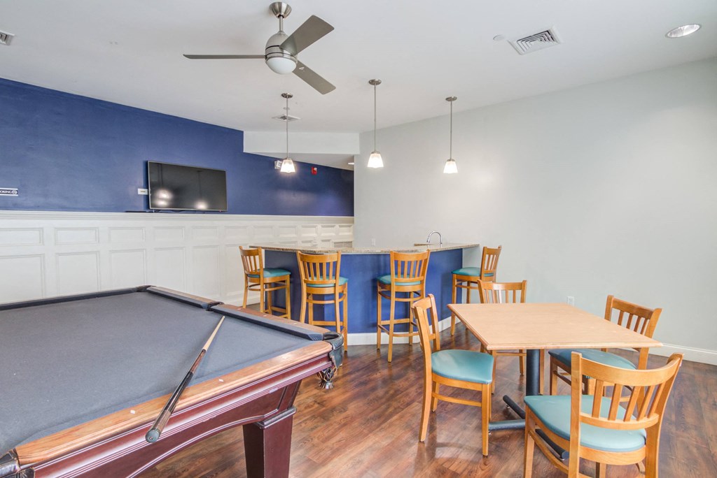 a room with a pool table and a table with chairs