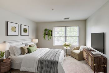 a bedroom with a bed and a chair and a television