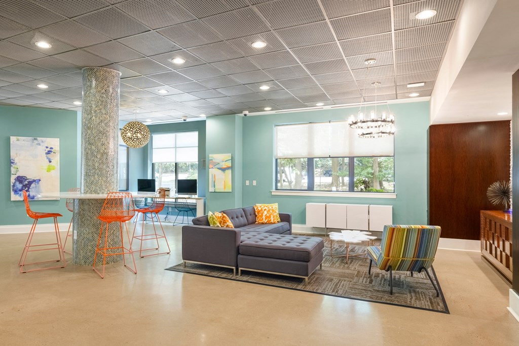 A living room with a grey couch and orange chairs.