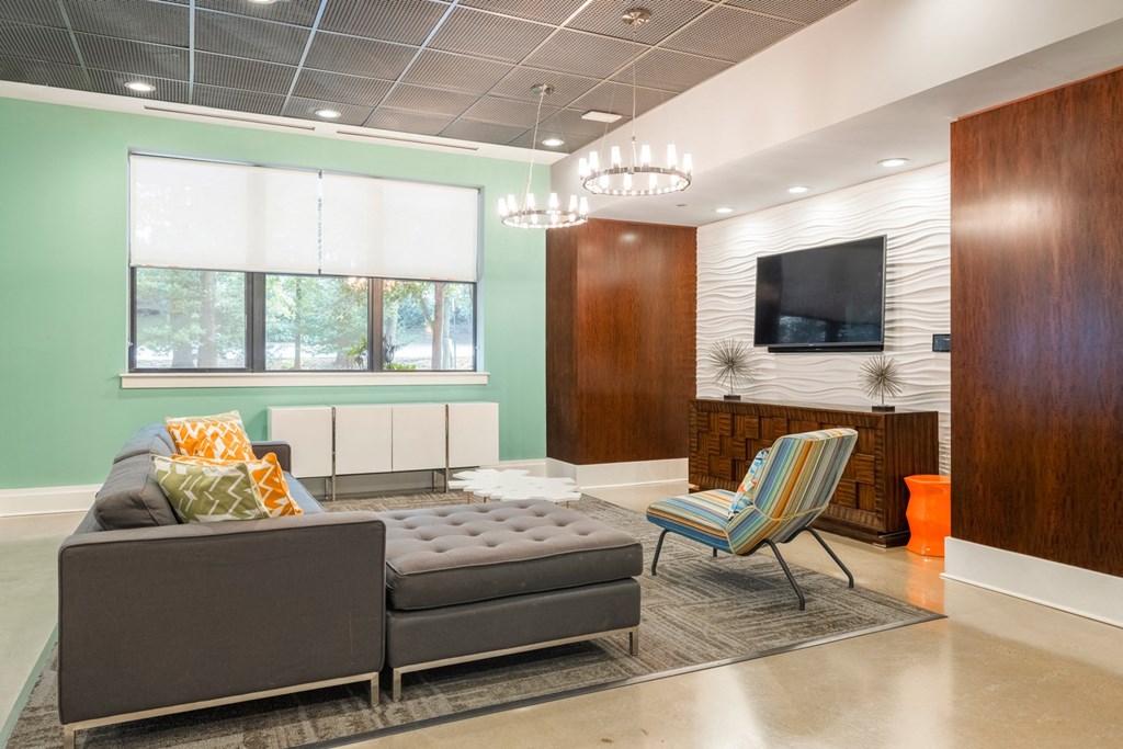 A living room with a grey couch and a striped chair.