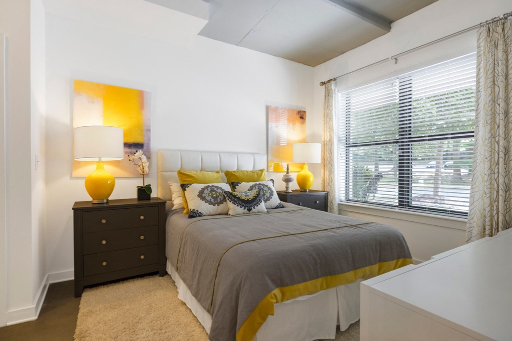 A bedroom with a bed, nightstand, and two lamps.