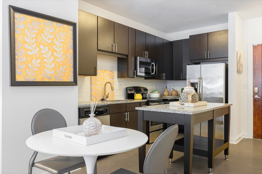 A modern kitchen with a white table and chairs.