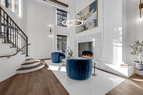 A modern living room with a staircase and a fireplace.