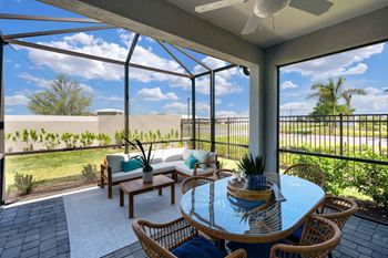 a patio with a table and chairs under a glass roof