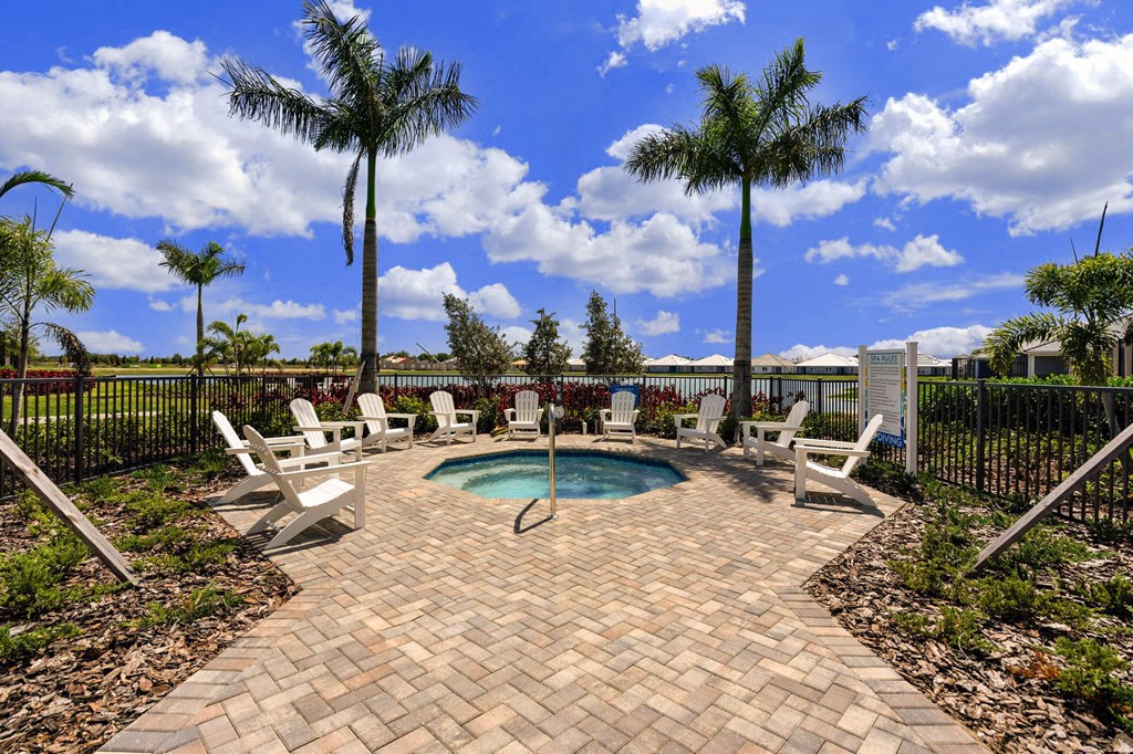 the pool is surrounded by chairs and palm trees