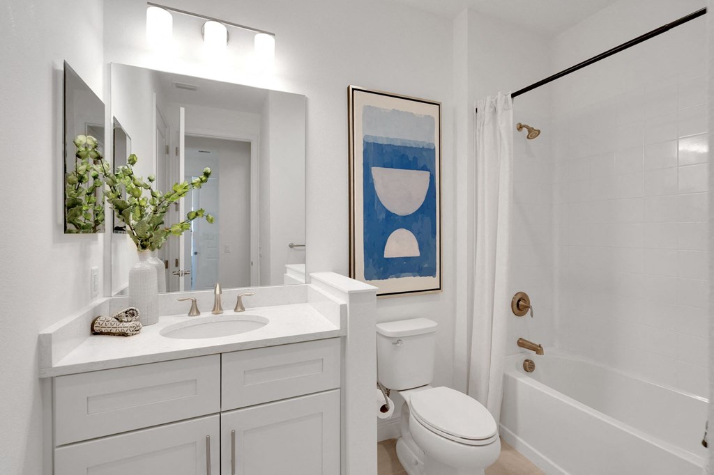 a white bathroom with a toilet sink and shower