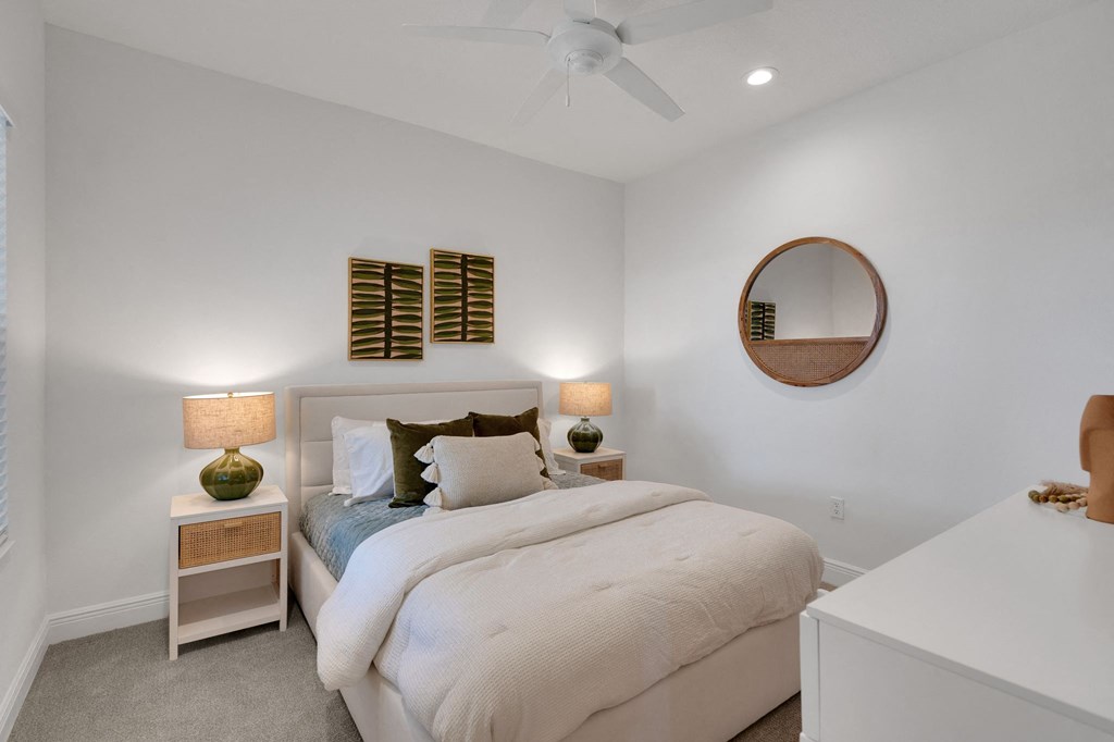a bedroom with a bed and a ceiling fan