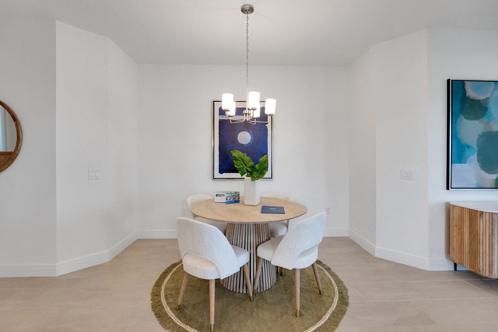 a dining room with a table and chairs and a painting on the wall