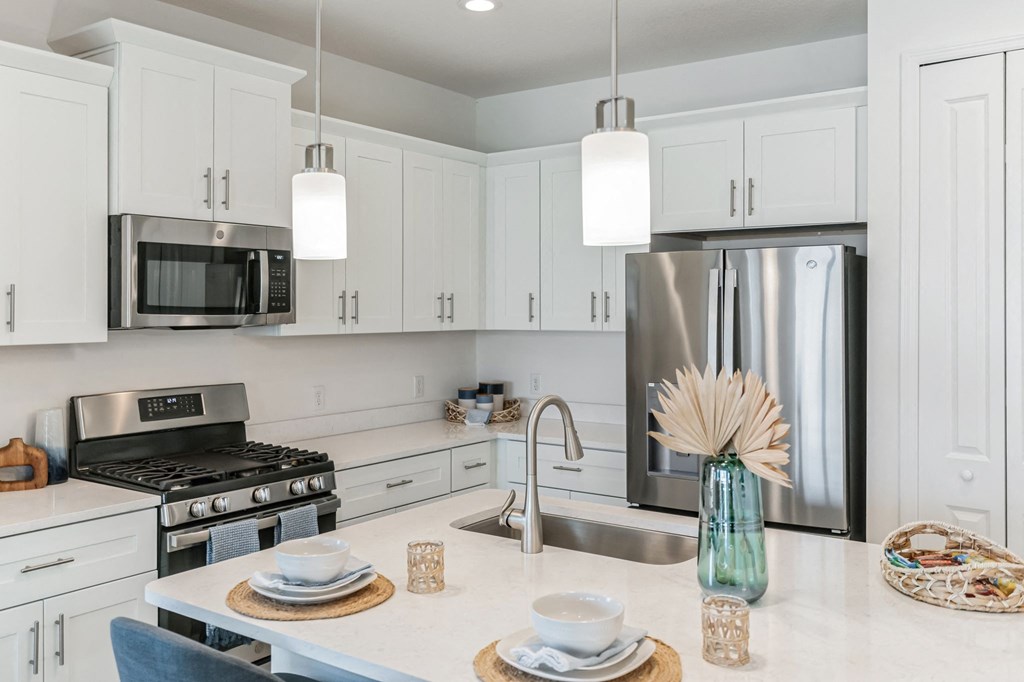 a kitchen with white cabinets and stainless steel appliances