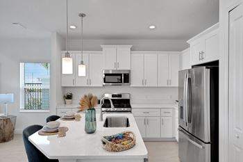 a white kitchen with stainless steel appliances and white cabinets