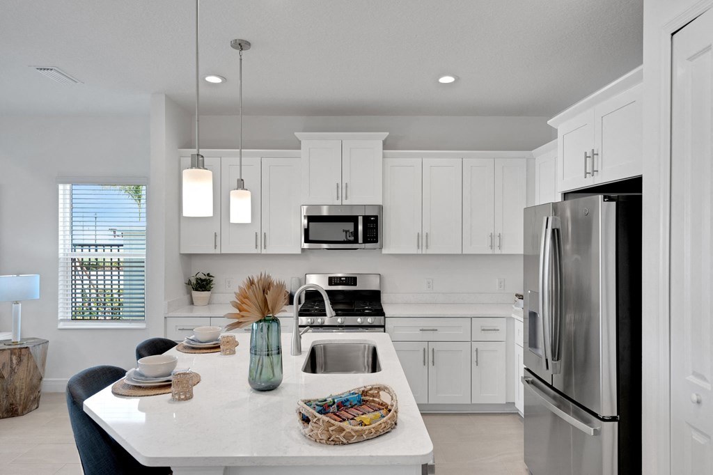a white kitchen with stainless steel appliances and white cabinets