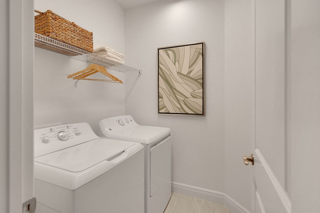 a laundry room with a washer and dryer and a painting on the wall