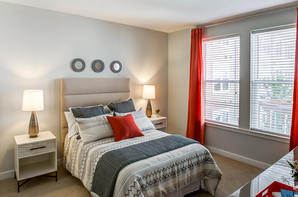 a bedroom with a bed and two windows