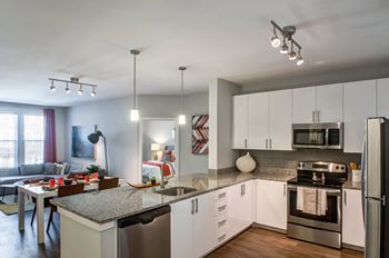 kitchen and living room with granite counter tops and stainless steel appliances