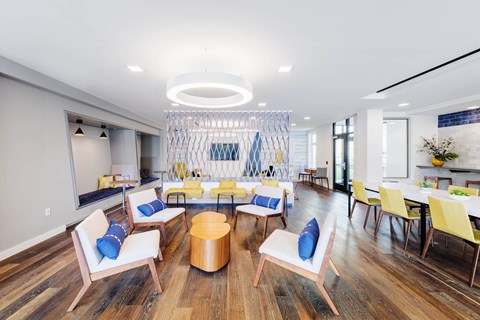 A modern living room with a circular wooden table and blue and white chairs.