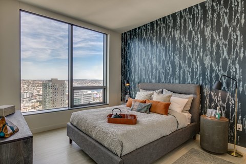 A bedroom with a large bed and a view of the city.