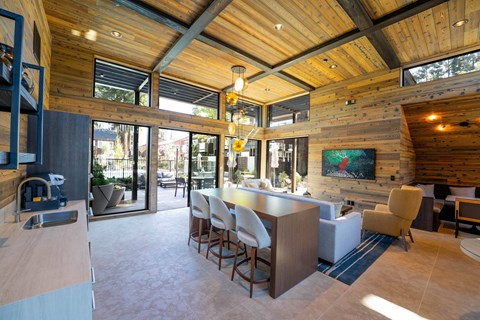 A modern kitchen with a wooden ceiling and a dining table with chairs.
