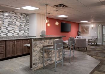 a lobby with a bar and chairs and a television
