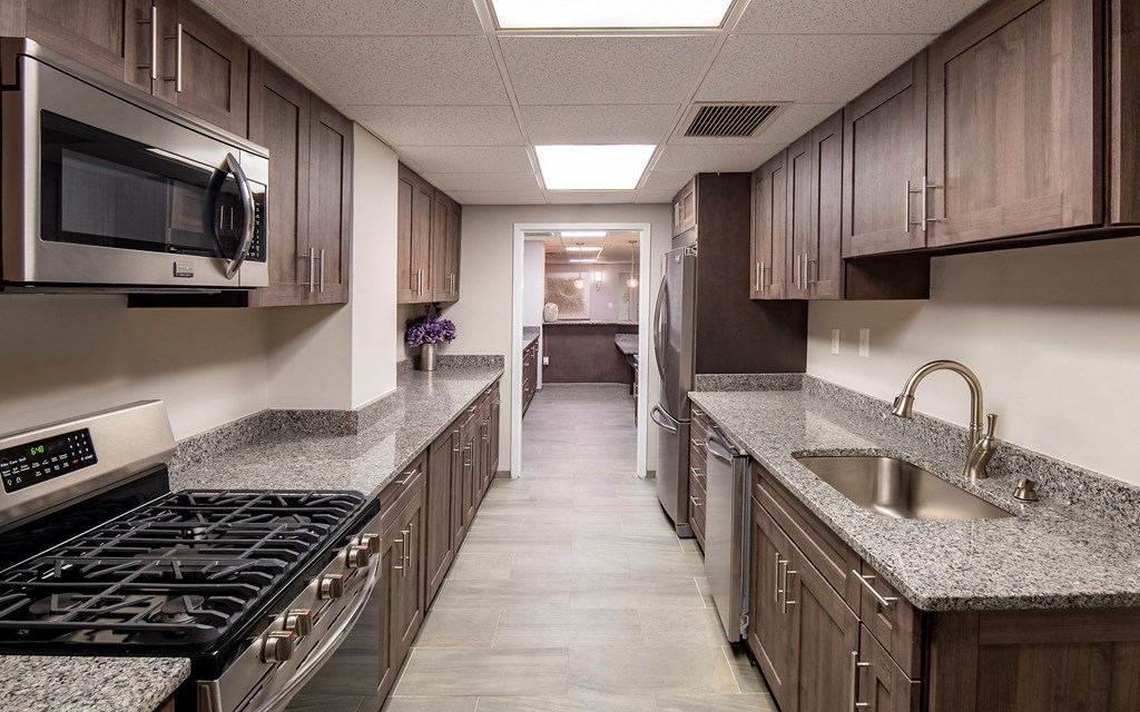 a kitchen with granite counter tops and wooden cabinets