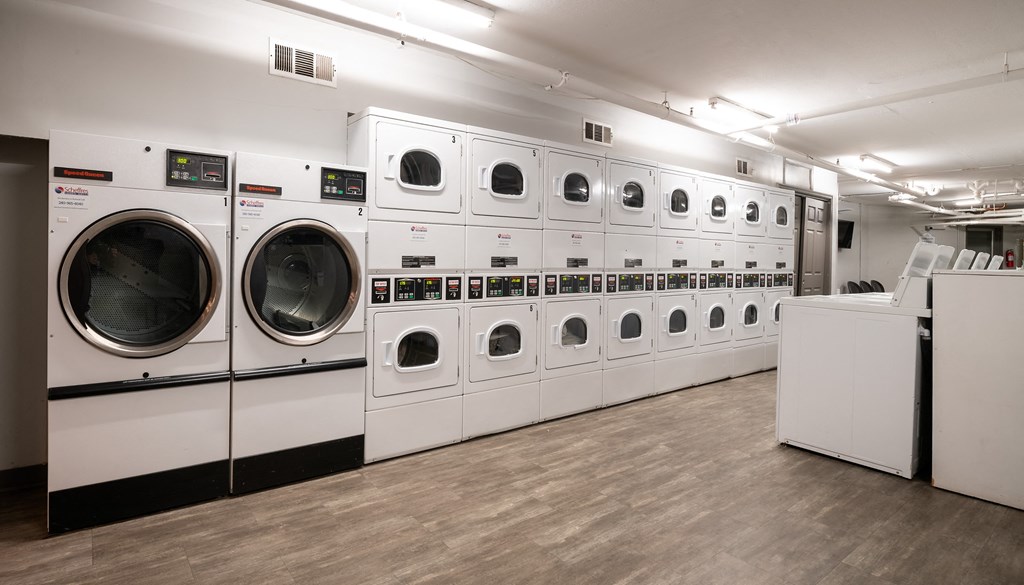 a row of washers and dryers in a laundry room