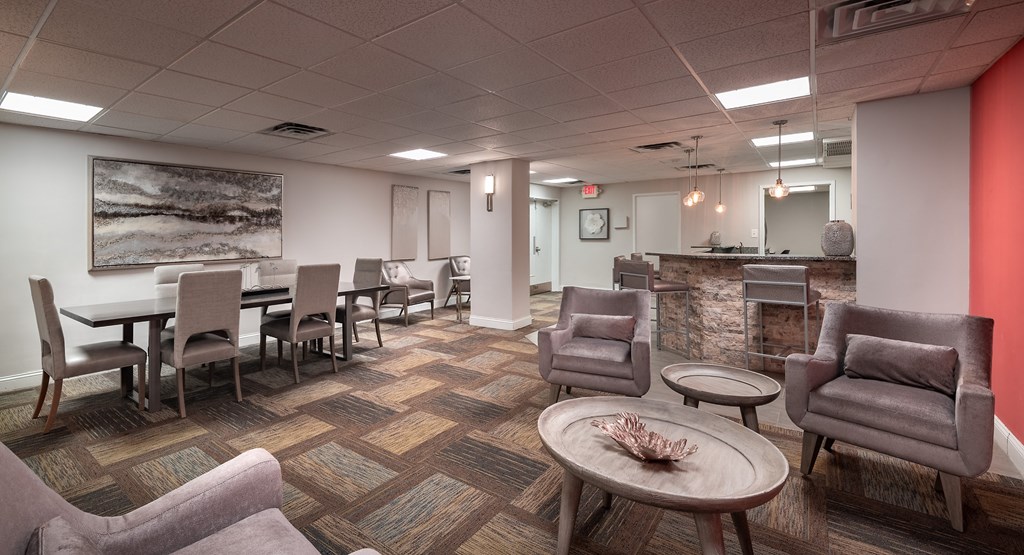 a lounge area with chairs and tables and a reception desk