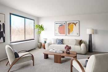 a living room with white furniture and a large window