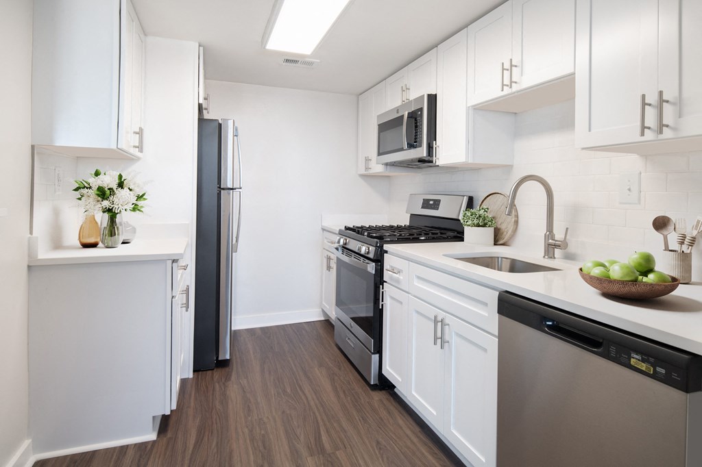 a kitchen with white cabinetry and stainless steel appliances