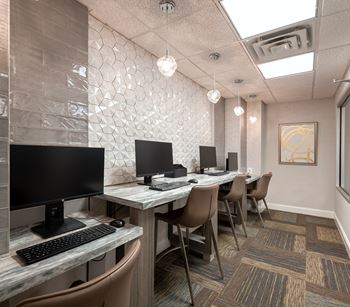 a computer room with a row of desks and chairs