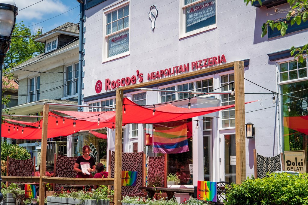a restaurant with red umbrellas in front of a white building