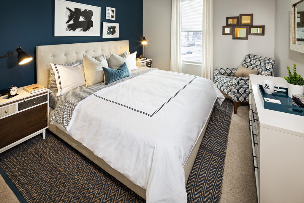 a bedroom with a large white bed and a blue accent wall