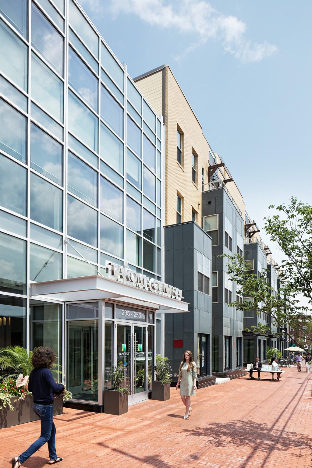 people walking in front of a building on a sidewalk